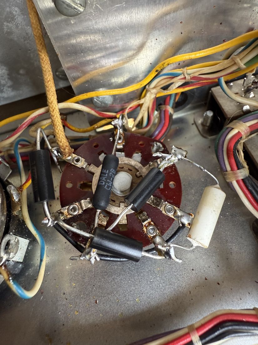 The back of a rotary selector switch, rewired with a ring of new resistors and a small white capacitor.