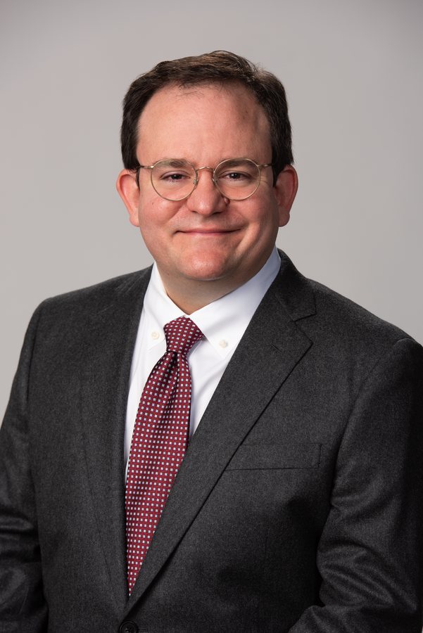 David Filippi, clean-shaven, in a dark suit and tie, photographed formally.